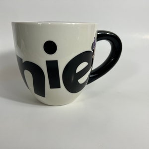 Puede incluir: Taza de cer&aacute;mica blanca con asa negra y la palabra "chic" escrita en letras negras.