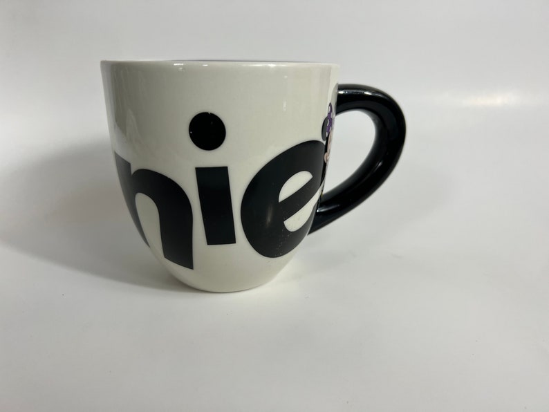 Puede incluir: Taza de cer&aacute;mica blanca con asa negra y la palabra "chic" escrita en letras negras.