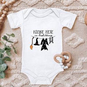 Blauwe ooievaar babyromper &quot;Kleine heks in training&quot; met spreuk cadeau voor de geboorte voor peuters van biologisch katoen met korte mouwen