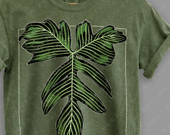 May include: A green t-shirt with a large, stylized, green leaf graphic. The shirt has a crew neck and short sleeves. The text "KILL ONLY TIME" is printed on the bottom of the shirt.