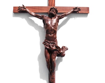 May include: A wooden crucifix with a brown Jesus figure, wearing a crown of thorns, with the inscription "INRI" on the top of the cross.