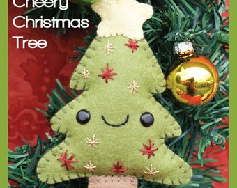 Könnte beinhalten: Ein handgefertigter Weihnachtsbaumschmuck aus Filz mit einem lächelnden Gesicht, roten und goldenen Sternakzenten und dem Text "Cheery Christmas Tree". Der grüne Schmuck hat einen beigen Stamm und einen weißen Stern. Er hängt an einem grünen Weihnachtsbaum mit goldenen und grünen Kugeln.