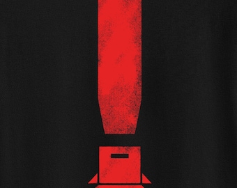 Pode incluir: Camiseta preta com um gráfico de um ponto de exclamação vermelho. O ponto de exclamação é estilizado com uma caixa na parte inferior.