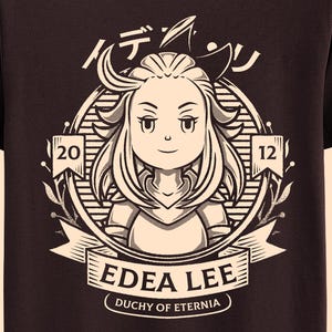 May include: A dark brown t-shirt with a circular graphic. The graphic features a cartoon character, Japanese text, and the text "EDEA LEE DUCHY OF ETERNIA" on a banner. The numbers "20" and "12" are on either side of the character.