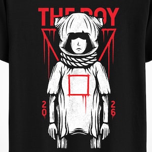 Puede incluir: Camiseta negra con un gráfico blanco de una figura con casco y bufanda, con el texto rojo "THE BOY" arriba. Líneas rojas enmarcan la figura, con los números "20" y "26" a cada lado.