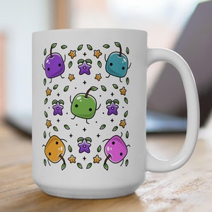 Könnte beinhalten: Weiße Keramiktasse mit einem farbenfrohen Cartoon-Design mit mehreren kleinen Fruchtfiguren mit Blättern und Sternen. Die Tasse hat einen großen Henkel.