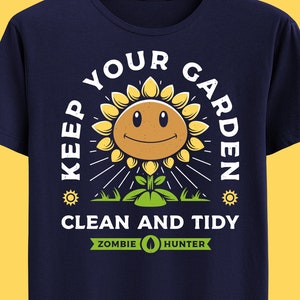 Puede incluir: Una camiseta azul marino con un gráfico blanco de un girasol sonriente con el texto "Keep Your Garden Clean and Tidy" y "Zombie Hunter" debajo del gráfico.