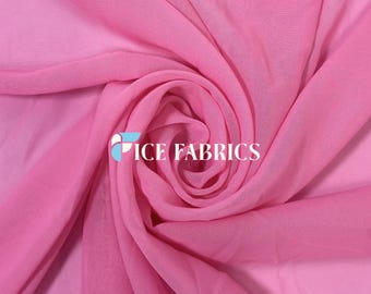 May include: A sheer, lightweight fabric in a vibrant shade of pink, arranged in a swirling, gathered pattern. The fabric features a translucent, fine-woven texture with soft folds. The text ICE FABRICS is printed in white over the center.