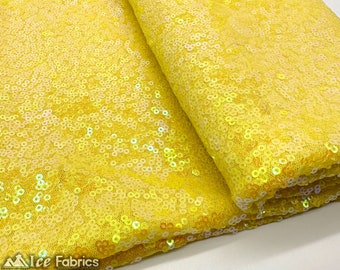May include: Yellow iridescent sequins on a mesh fabric. The sequins are small and closely spaced, creating a shimmering effect.