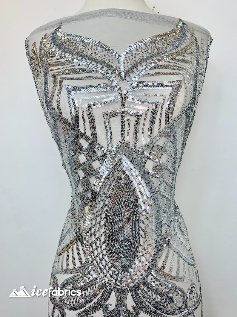 May include: Silver and gold sequined fabric with a geometric design. The fabric is on a white mannequin.
