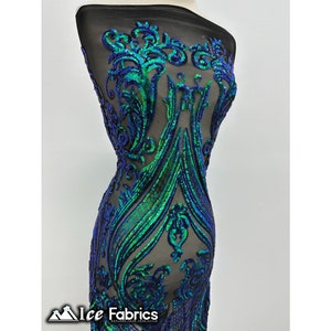 May include: Green and blue iridescent sequins on a black mesh fabric. The sequins are arranged in a floral pattern.
