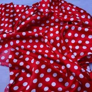 Puede incluir: Tela roja con lunares blancos. La tela está doblada y drapeada, mostrando la textura del material.