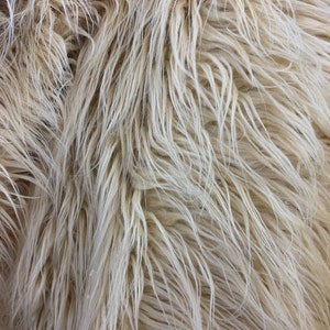 May include: Close-up of a soft, fluffy, white faux fur fabric. The texture is very plush and resembles real fur.