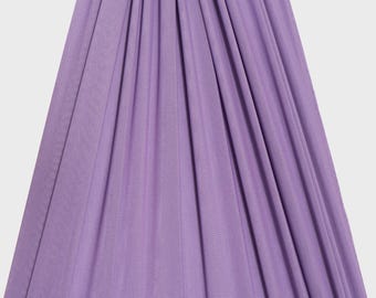 May include: A length of solid light purple fabric draped in vertical folds, creating a series of soft, cascading pleats. The material has a smooth, fine-knit texture. A logo with the text ICE FABRICS is visible in the bottom left corner.