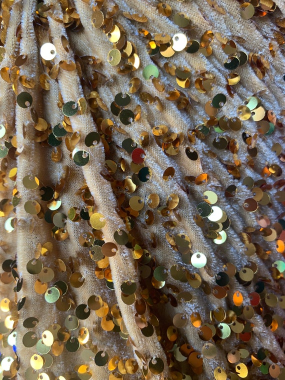 A Pile Of Gold Sequin Pins For Arts And Crafts On A White