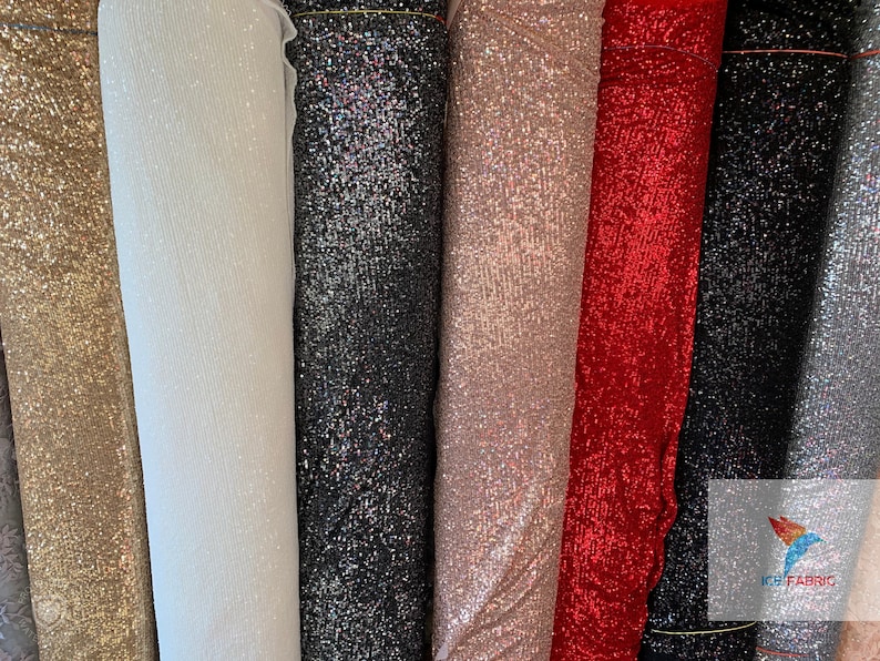 May include: A variety of sparkly fabrics in gold, white, black, pink, red, and silver. The fabrics are all sequined and have a shimmery finish.