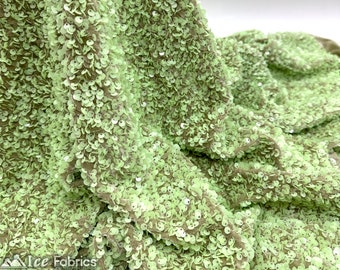 May include: Green sequin fabric with a subtle sheen. The sequins are small and densely packed, creating a textured surface.