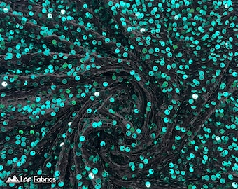 May include: Black velvet fabric with teal sequins. The sequins are scattered randomly across the fabric.