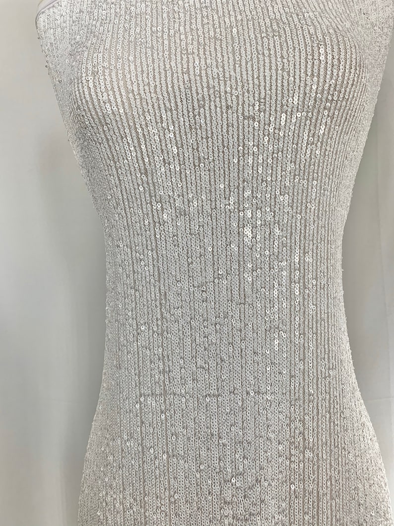 May include: White fabric with a vertical pattern of small, iridescent sequins.
