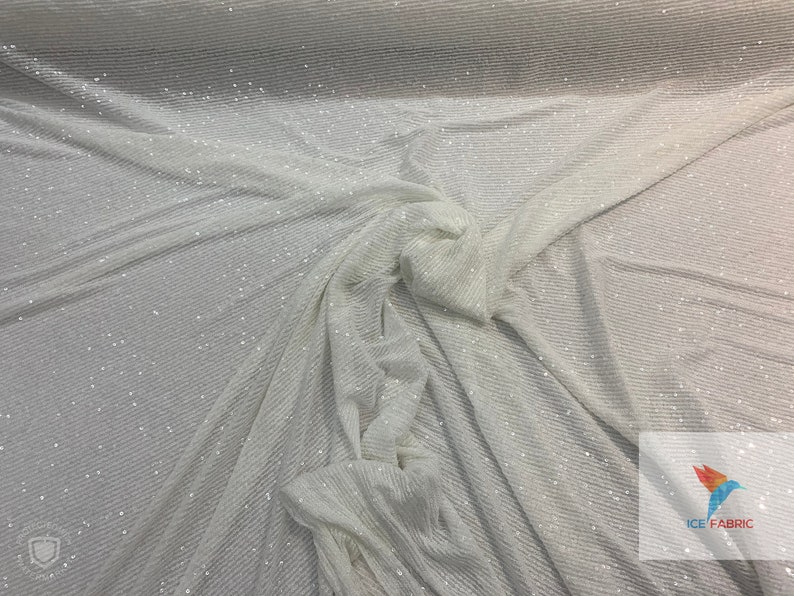 May include: White fabric with a subtle shimmer and a ribbed texture. The fabric is draped and folded, showing the texture and sheen.