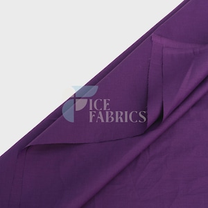 May include: A solid deep purple fabric folded to show its texture and drape. The material has a smooth, matte finish and a consistent colour throughout. A semi-transparent logo with the text ICE FABRICS is overlaid on the centre of the fabric.