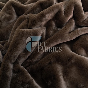 May include: A dark brown faux fur fabric with a soft, dense texture and deep folds. The surface features a consistent, plush pile throughout. A semi-transparent logo with the text ICE FABRICS is overlaid on the center of the brown material.