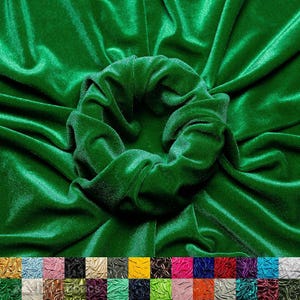 May include: A vibrant green velvet scrunchie, centered in the image, surrounded by lush, emerald green velvet fabric. The fabric is draped, creating soft folds and shadows. A palette of additional velvet colors is displayed at the bottom.