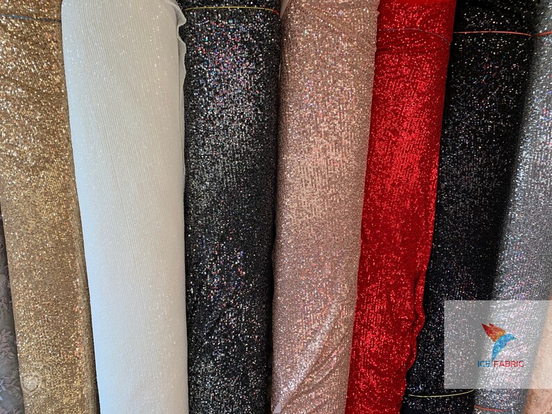 May include: A variety of sparkly fabrics in different colors, including gold, white, black, pink, red, and silver. The fabrics are all sequined and have a shimmering effect.
