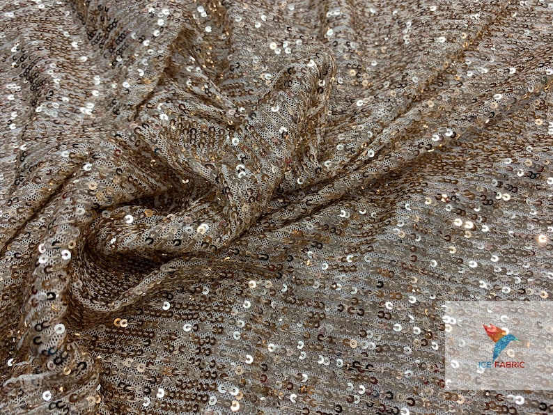May include: Gold sequin fabric with a subtle shimmer. The fabric is woven with a fine mesh backing and features small, round sequins.