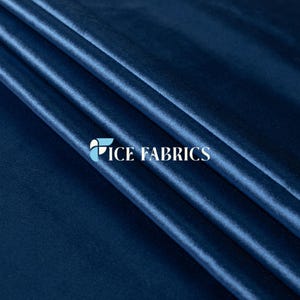 Op de afbeelding: Close-up van een gevouwen, diepblauwe fluwelen stof. De stof heeft een zachte glans en zichtbare plooien, waardoor schaduwen en highlights ontstaan. De tekst "ICE FABRICS" is in het wit gedrukt.