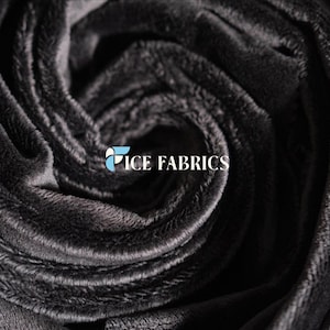 Può includere: Un tessuto in velluto grigio antracite scuro con una consistenza morbida e felpata, disposto in un motivo a spirale con pieghe. Il logo ICE FABRICS è stampato in lettere bianche e azzurre al centro delle pieghe del tessuto.
