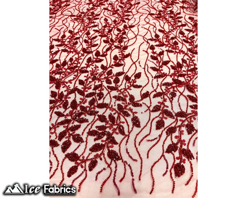 Puede incluir: Tela de encaje roja con cuentas con un patr&oacute;n floral. La tela tiene una base de malla transparente con peque&ntilde;as cuentas rojas y lentejuelas que forman un delicado dise&ntilde;o de hojas.