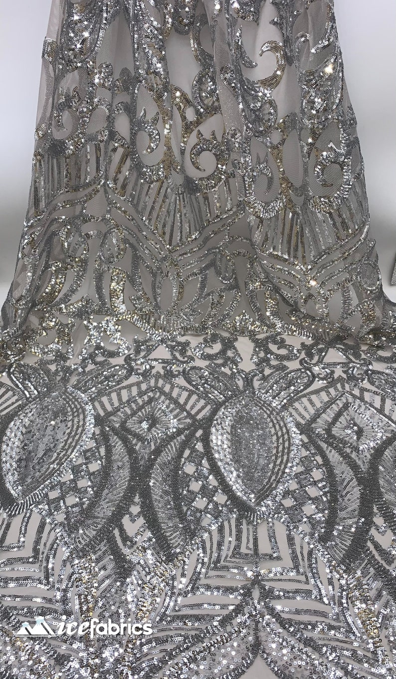 May include: Silver and gold sequined fabric with a geometric pattern. The fabric is sheer and has a delicate, shimmering look.