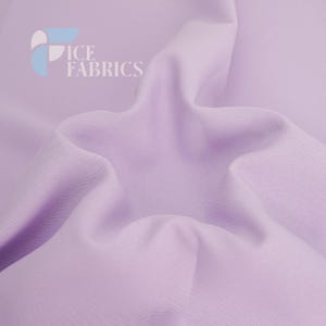 May include: A solid light lavender fabric with a smooth, matte texture and soft, flowing folds. The top left corner features a logo with the text ICE FABRICS in white, accompanied by a stylized graphic element in light blue, white, and lavender.