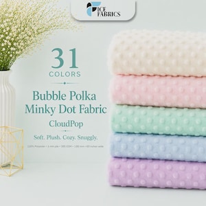 Może przedstawiać: Stos pięciu złożonych tkanin Bubble Polka Minky Dot w kolorach kremowym, jasnoróżowym, miętowym, jasnoniebieskim i lawendowym. Tekst zawiera Ice Fabrics, 31 Colors, Bubble Polka Minky Dot Fabric, CloudPop, 100% poliester, 3 mm włos, 385 GSM, 1.00 mm, 152 cm szerokości.