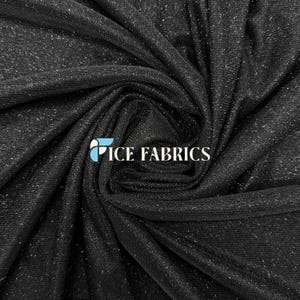Pode incluir: Tecido preto com um efeito de brilho subtil, tecido firmemente e drapeado. O tecido tem uma textura suave e é adequado para projetos de vestuário e artesanato. O logótipo "ICE FABRICS" é visível na parte inferior central.