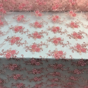 May include: Pink floral embroidered lace fabric with sequins. The lace has a delicate floral pattern with 3D flowers and a sheer mesh background.