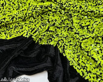 May include: Close-up of a black fabric with a velvety texture, partially covered with bright neon green sequins. The sequins are clustered together, creating a textured, eye-catching design. The fabric is likely used for apparel or decorative purposes.