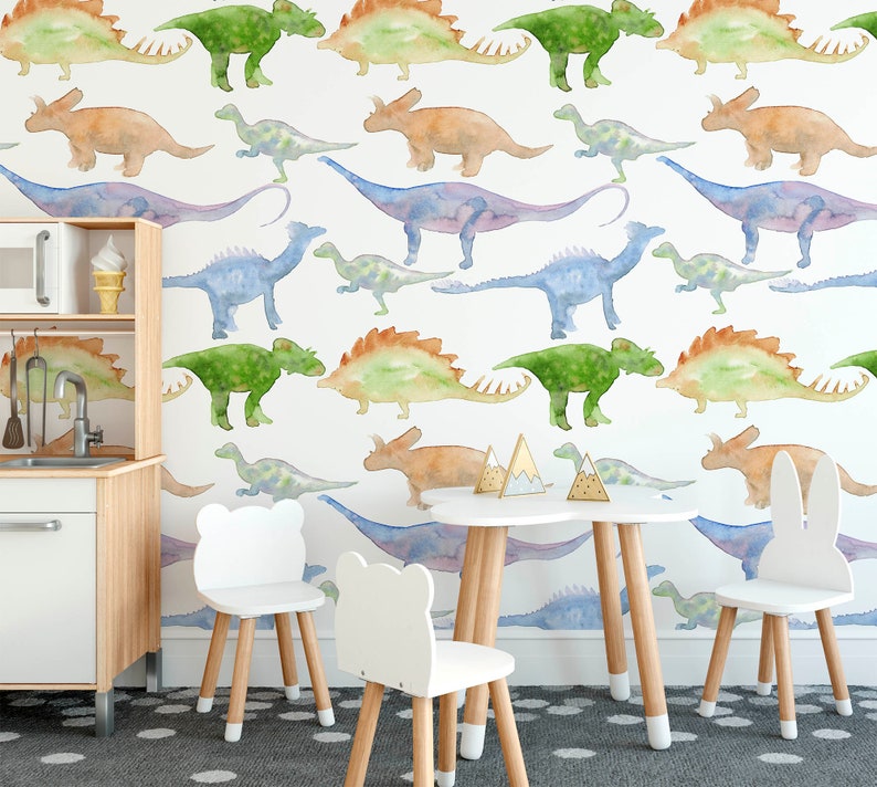 May include: A white play table with four chairs in a room with a wall covered in a watercolor dinosaur wallpaper. The chairs are white with wooden legs and one chair has bunny ears.