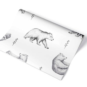 Puede incluir: Papel de regalo blanco con un patr&oacute;n repetido de osos negros y blancos. Los osos est&aacute;n dibujados de forma simple y estilizada.