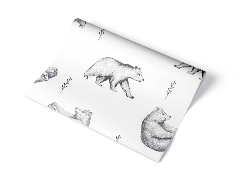 Puede incluir: Papel de regalo blanco con un patr&oacute;n repetido de osos negros y blancos. Los osos est&aacute;n dibujados de forma simple y estilizada.