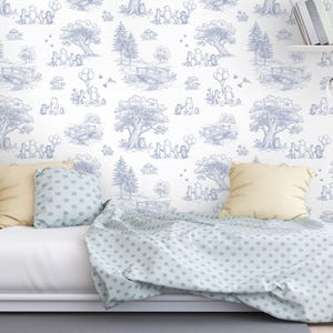 May include: A white and blue toile wallpaper featuring a repeating pattern of a forest scene with cartoon characters, trees, bridges, and balloons. The bed has a light blue polka dot blanket and pillow with a yellow pillow.