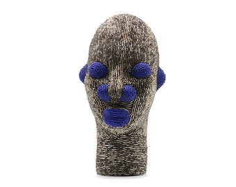 May include: A beaded sculpture of a human head with a gold and black finish. The sculpture has blue beads for eyes, nose, and mouth.