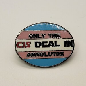 May include: A round pin with a transgender pride flag design. The pin says "Only the cis deal in absolutes" in black text on a white background.