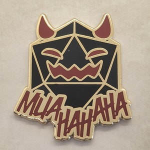 May include: A black and gold enamel pin with a red devil face and the text "MUAHAHAHA" in red.