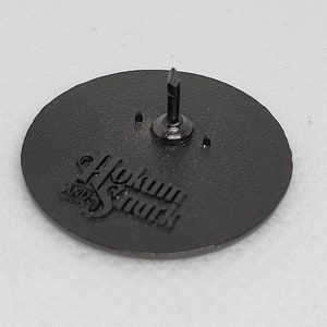 K&ouml;nnte beinhalten: Schwarzer Metallstift mit kreisf&ouml;rmigem Design. Der Stift tr&auml;gt den Text "Hokum & Smack" in einer stilisierten Schrift.