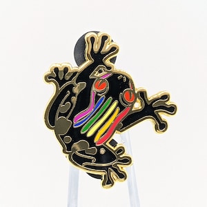 May include: A black and gold frog pin with a rainbow stripe down its back. The frog has red eyes and is in a jumping pose.