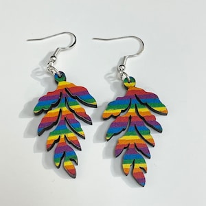 Op de afbeelding: Regenboogkleurige, gestreepte oorhangers in de vorm van een blad met zilveren haakjes.