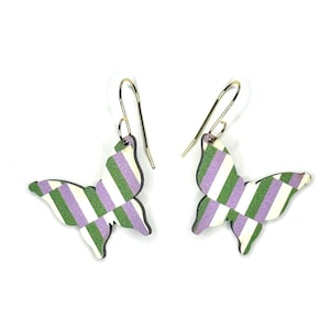 Op de afbeelding: Een paar vlindervormige oorbellen. Elke oorbel heeft een groen, wit en paars gestreept patroon. De oorbellen hebben goudkleurige oorhaken en een zwarte omtrek. De achtergrond is wit.