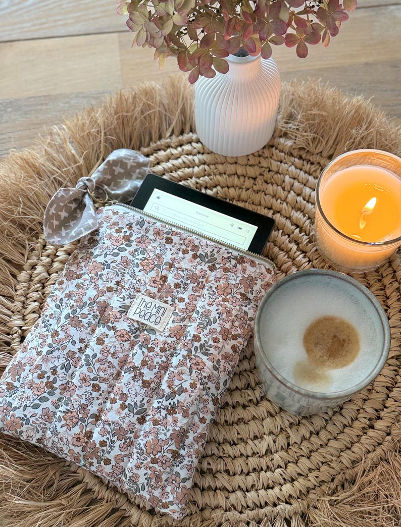 Eine Tablet-Hülle mit floralem Muster und goldenem Reißverschluss. E-Reader Hülle im Musterstoff.